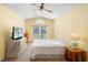 Inviting bedroom with light-yellow walls and vaulted ceiling featuring a ceiling fan and window at 2530 Leonard Dr, Deltona, FL 32725