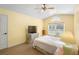 Inviting bedroom with light-yellow walls and vaulted ceiling featuring a ceiling fan and window at 2530 Leonard Dr, Deltona, FL 32725