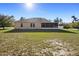 Back exterior of the home with a screened lanai and spacious yard; ready for Gathering fun! at 2530 Leonard Dr, Deltona, FL 32725