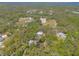 Aerial showcasing property with equestrian facilities, lush trees, and surrounding neighborhood at 2646 Turnbull Bay Rd, New Smyrna Beach, FL 32168