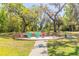 Picturesque backyard with a wooden deck area featuring colorful chairs, perfect for outdoor relaxation and enjoyment at 2646 Turnbull Bay Rd, New Smyrna Beach, FL 32168