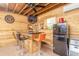 Basement bar area featuring a bar with stools, a mini fridge, and custom wood accents at 2646 Turnbull Bay Rd, New Smyrna Beach, FL 32168