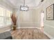 Bright dining area with tray ceiling, modern chandelier, and large windows with plantation shutters at 2646 Turnbull Bay Rd, New Smyrna Beach, FL 32168
