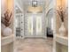 Bright foyer with decorative glass double doors, wood-look tile flooring, and arched transom window at 2646 Turnbull Bay Rd, New Smyrna Beach, FL 32168