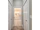 Hallway with tile flooring leading to a bathroom, offering storage with closets, providing convenient access at 2646 Turnbull Bay Rd, New Smyrna Beach, FL 32168
