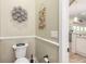 Well-maintained powder room featuring a white toilet, coastal decor, and neutral walls at 2646 Turnbull Bay Rd, New Smyrna Beach, FL 32168