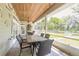 Inviting screened porch with wood ceiling, outdoor dining area, and serene views of the lush backyard at 2646 Turnbull Bay Rd, New Smyrna Beach, FL 32168