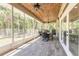 Large screened porch featuring a wood-look tile floor, outdoor ceiling fans, and views of the backyard at 2646 Turnbull Bay Rd, New Smyrna Beach, FL 32168