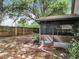 Backyard view showcasing the screened-in patio and a glimpse of the surrounding fenced yard and mature trees at 30029 Pga Dr, Sorrento, FL 32776