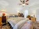 The inviting bedroom has a ceiling fan, patterned carpet, and bright natural light at 30029 Pga Dr, Sorrento, FL 32776