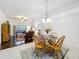 Elegant dining area with a glass-top table, wooden chairs, and open living space at 30029 Pga Dr, Sorrento, FL 32776