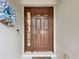 Close up of solid wood front door with sidelight and decorative wreath at 30029 Pga Dr, Sorrento, FL 32776