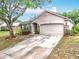 Charming home features a stone accent wall, well-manicured landscaping, and an attached two car garage at 30029 Pga Dr, Sorrento, FL 32776