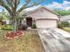Charming home features a stone accent wall, well-manicured landscaping, and an attached two car garage at 30029 Pga Dr, Sorrento, FL 32776