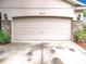 Close up of the home's garage door with stone accents and decorative lighting at 30029 Pga Dr, Sorrento, FL 32776