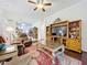 Comfortable living room featuring hardwood floors, ceiling fan, and TV entertainment center at 30029 Pga Dr, Sorrento, FL 32776