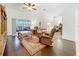 Comfortable living room with hardwood floors, ceiling fan, and access to the screened-in porch at 30029 Pga Dr, Sorrento, FL 32776