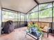 The enclosed patio has comfortable seating and views of the backyard at 30029 Pga Dr, Sorrento, FL 32776