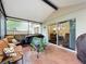Inviting screened patio with cozy seating area and adjacent sliding glass doors for indoor-outdoor living at 30029 Pga Dr, Sorrento, FL 32776