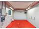A spacious basement area, with painted walls and red concrete flooring, offers a versatile area for storage or workshop at 3005 Garden Rd, Eustis, FL 32726
