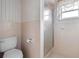 Tiled bathroom features a toilet, glass-enclosed shower, and a window that allows for natural light at 3005 Garden Rd, Eustis, FL 32726
