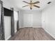 Bedroom with wood-look floors and ceiling fan has closet, window, and television at 3005 Garden Rd, Eustis, FL 32726
