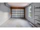 Spacious garage interior features a light gray door, side window, and overhead storage racks, offering ample parking and storage space at 3005 Garden Rd, Eustis, FL 32726