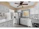 Open concept kitchen featuring stainless steel appliances, white cabinets, and tiled backsplash at 3005 Garden Rd, Eustis, FL 32726