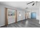 Bright living room featuring wood-look floors and natural light from large windows with neutral curtains at 3005 Garden Rd, Eustis, FL 32726