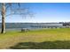 Scenic waterfront view with a picnic table on the lawn offers a relaxing lakeside experience at 3005 Garden Rd, Eustis, FL 32726