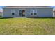 A simple backyard with a patio and a view of the back of the house at 303 Puffer Ct, Kissimmee, FL 34759