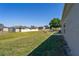 Image of a green backyard with a simple patio, the home's exterior, and a view of the surrounding homes at 303 Puffer Ct, Kissimmee, FL 34759