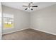 Bedroom featuring neutral walls, carpet flooring, a ceiling fan, and a view of the backyard through a window at 303 Puffer Ct, Kissimmee, FL 34759