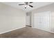 Bedroom featuring neutral walls, a ceiling fan, closet with double doors, and carpet flooring at 303 Puffer Ct, Kissimmee, FL 34759