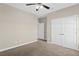 Carpeted bedroom with ceiling fan and double-door closet for ample storage at 303 Puffer Ct, Kissimmee, FL 34759