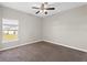 Carpeted room featuring neutral walls, a ceiling fan, and a window offering natural light and a view to the neighborhood at 303 Puffer Ct, Kissimmee, FL 34759
