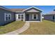 Charming single-story home featuring a well-maintained lawn and a welcoming front porch at 303 Puffer Ct, Kissimmee, FL 34759