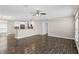 Open-concept living room features hardwood floors, ceiling fan, and seamless flow into a modern kitchen at 303 Puffer Ct, Kissimmee, FL 34759