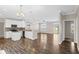 Open-concept living area showcasing hardwood floors, a modern kitchen with white cabinets, and a view to the backyard at 303 Puffer Ct, Kissimmee, FL 34759