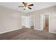 Main bedroom with neutral walls, carpet flooring, and a ceiling fan, with access to the bathroom and walk-in closet at 303 Puffer Ct, Kissimmee, FL 34759