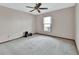 This cozy carpeted bedroom features a ceiling fan and window at 3041 Millstone Ave, Deltona, FL 32738