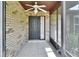 Welcoming front entrance featuring a tiled floor, brick walls, and a ceiling fan for added comfort at 3041 Millstone Ave, Deltona, FL 32738