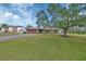 Well-maintained home featuring a spacious front lawn, mature tree, and driveway leading to a two-car garage at 3041 Millstone Ave, Deltona, FL 32738