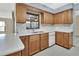Bright kitchen with wooden cabinetry, a dual stainless steel sink, white dishwasher, and a tiled backsplash at 3041 Millstone Ave, Deltona, FL 32738