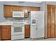 Well-lit kitchen features wooden cabinets, a modern white refrigerator with water dispenser, and a white range at 3041 Millstone Ave, Deltona, FL 32738