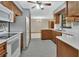 Traditional kitchen features wooden cabinets, white appliances, and a stylish ceiling fan, perfect for culinary enthusiasts at 3041 Millstone Ave, Deltona, FL 32738