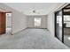 Spacious living room with neutral carpet, bright windows, and sliding glass doors, providing ample natural light at 3041 Millstone Ave, Deltona, FL 32738