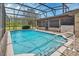 Sparkling swimming pool with screen enclosure, surrounded by patio and well-kept landscaping at 3041 Millstone Ave, Deltona, FL 32738