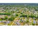 Aerial view of home with solar panels situated in a vibrant, lush green residential neighborhood at 3104 Umbrella Tree Dr, Edgewater, FL 32141