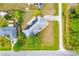 Aerial view of house with solar panels, light gray roof, and long driveway in a residential area at 3104 Umbrella Tree Dr, Edgewater, FL 32141